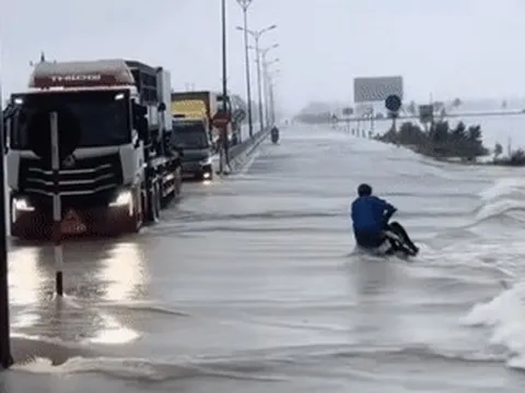 Khoảnh khắc đoàn xe tải làm 'lá chắn' giúp người đi xe máy vượt lũ gây xúc động